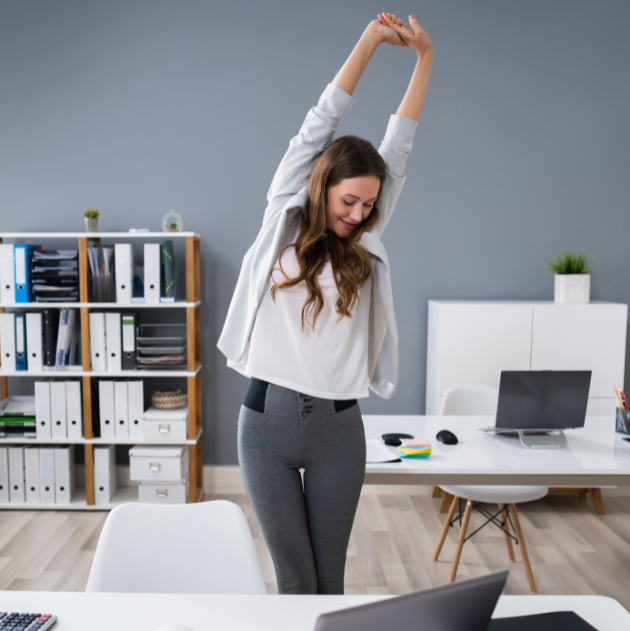 A person stretching during a work break is an example of movement snacking for office workers.