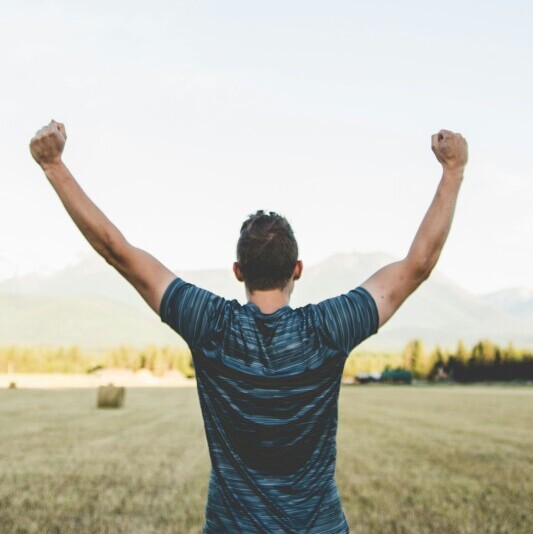 Face your fears and win. A man with open arms celebrating an achievement.