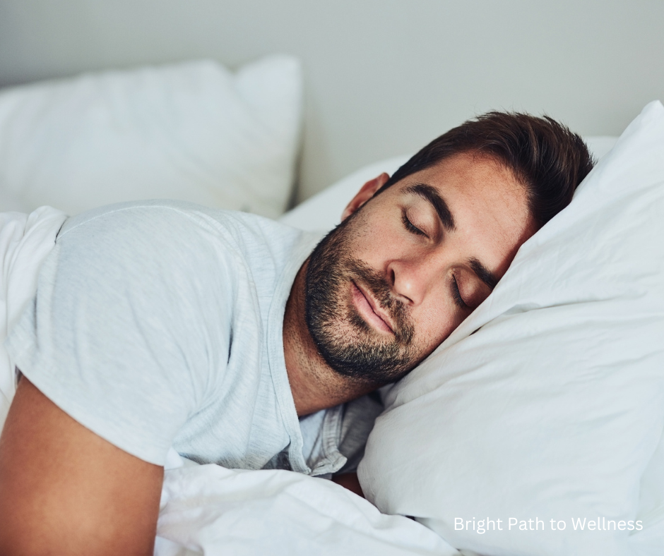 Man sleeping on his side on a pillow and white sheet.